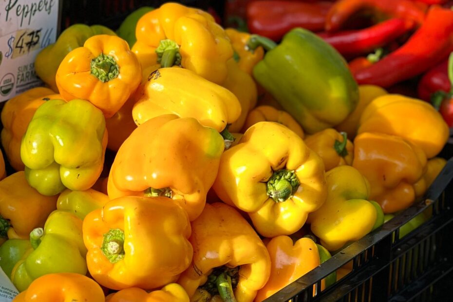 Stacked crates of bell peppers at a farmers market
